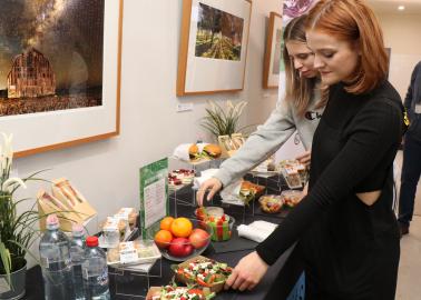 Two women select food from the new Healthier Choices range